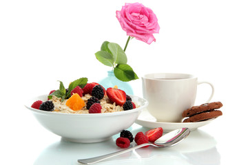 tasty oatmeal with berries and cup of tea, isolated on white