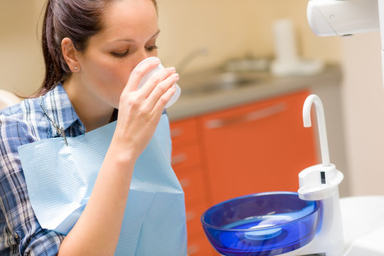 Dental patient woman wash mouth after treatment