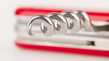 Red swiss army knife isolated, focus on corkscrew