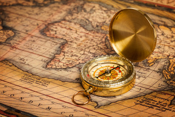 Old vintage golden compass on ancient map
