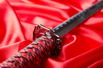 Japanese sword takana on red satin background
