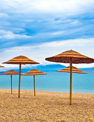 A straw umbrella on a tropical beach with blue sky