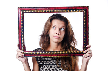 Young woman with picture frame on white