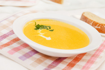 Pumpkin soup in white bowl