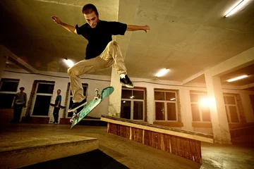Fotobehang Young man performing a stunt in a skatepark © Nejron Photo