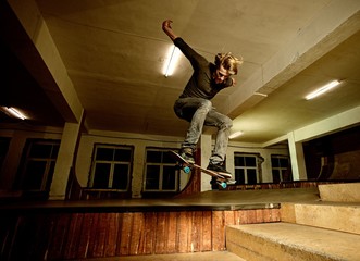 Young man performing a stunt in a skatepark