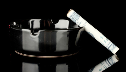 Cigarette of the 100 dollar bill and an ashtray isolated