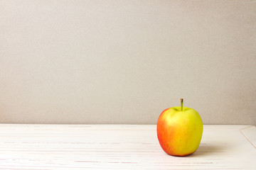 Apple on white wooden table and grey grunge background