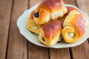 Fresh buns on plate on wooden table