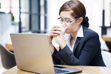 Businesswoman drinking coffee at cafe