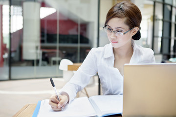 Businesswoman writes on a document