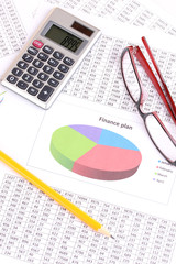 Documents, calculator and glasses close-up.