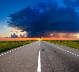 asphalt road to a sunset