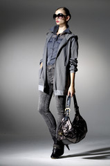 High fashion model with bag posing in light the studio