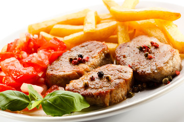 Grilled steaks, French fries and vegetables