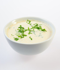 Bowl of thick fish soup over white background