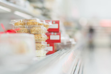 Variety of bisciut and chocolate cakes on shelves in supermarket
