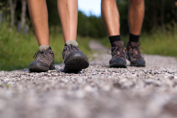 Closeup of two pairs of hiking boots on a trail