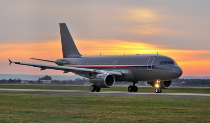 Fototapeta na wymiar Samolot na pasie startowym na zachodzie słońca