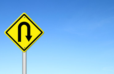 Yellow warning sign u-turn roadsign with blue sky background