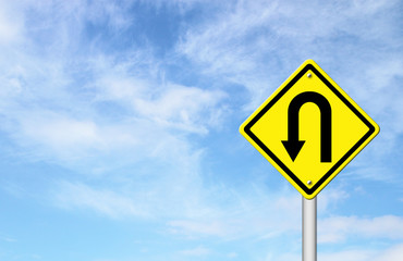Yellow warning sign u-turn roadsign with blue sky background