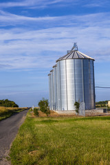 four silver silos in corn field