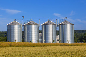four silver silos in corn field © travelview