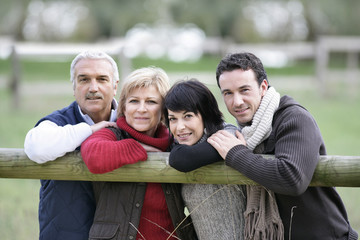 Family leaning against fence