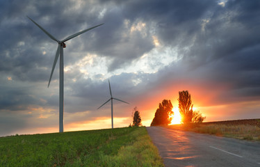 Old road and wind power generators at the sunset