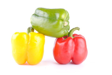 three colorful peppers on white, soft shadows