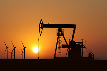oil pump silhouette in sunset and alternative energy