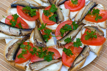 Sandwiches with sprats on a plate