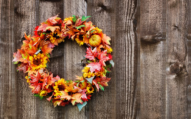 Autumn flower wreath on rustic wooden fence