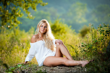 Sexy blonde girl in white dress on the farm