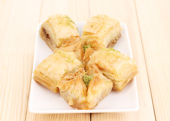 Sweet baklava on plate on wooden background