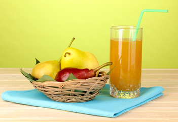 Pear juice with pears on wooden table on yellow background