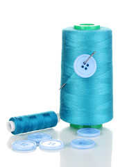 Blue bobbin with needle and buttons isolated on white