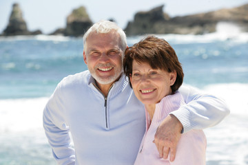 Obraz premium Old couple strolling along the beach