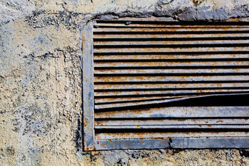 Old rusty ventilation grille  Textured wall with bulging paint
