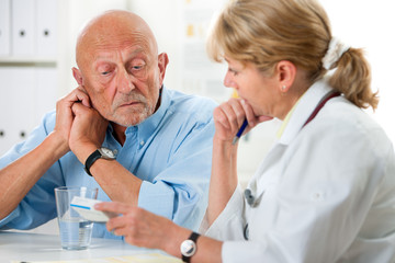 Ärztin berät einen älteren Patienten