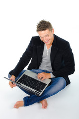 Smiling young man working at laptop