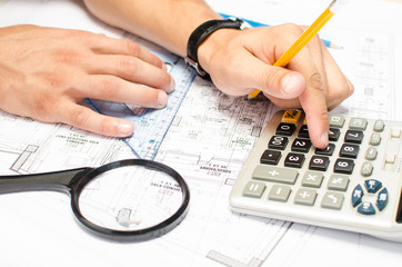 Man working with a calculator and square drawing