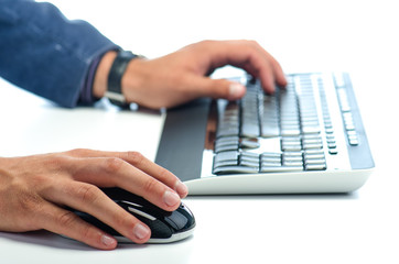 Man's hands working with computer mouse and  computer keyboard