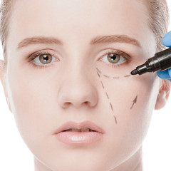 Beautician draw correction lines on woman face