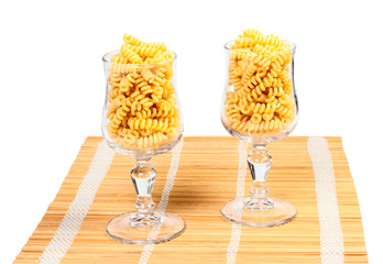 Macaroni in a glass on a straw mat