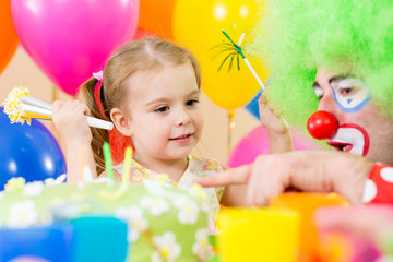 happy child girl with clown on birthday party