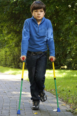 Gehbehinderter Junge mit Gehhilfen