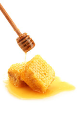 golden honeycombs and wooden drizzler with honey isolated