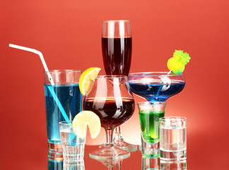 a variety of alcoholic drinks on red background