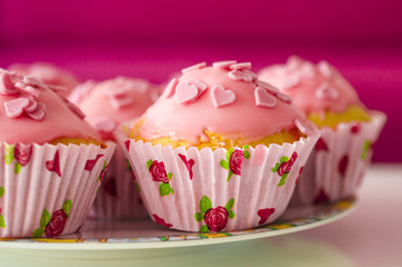 Leckere glasierte Mini-Kuchen verziert mit Zuckerherzen